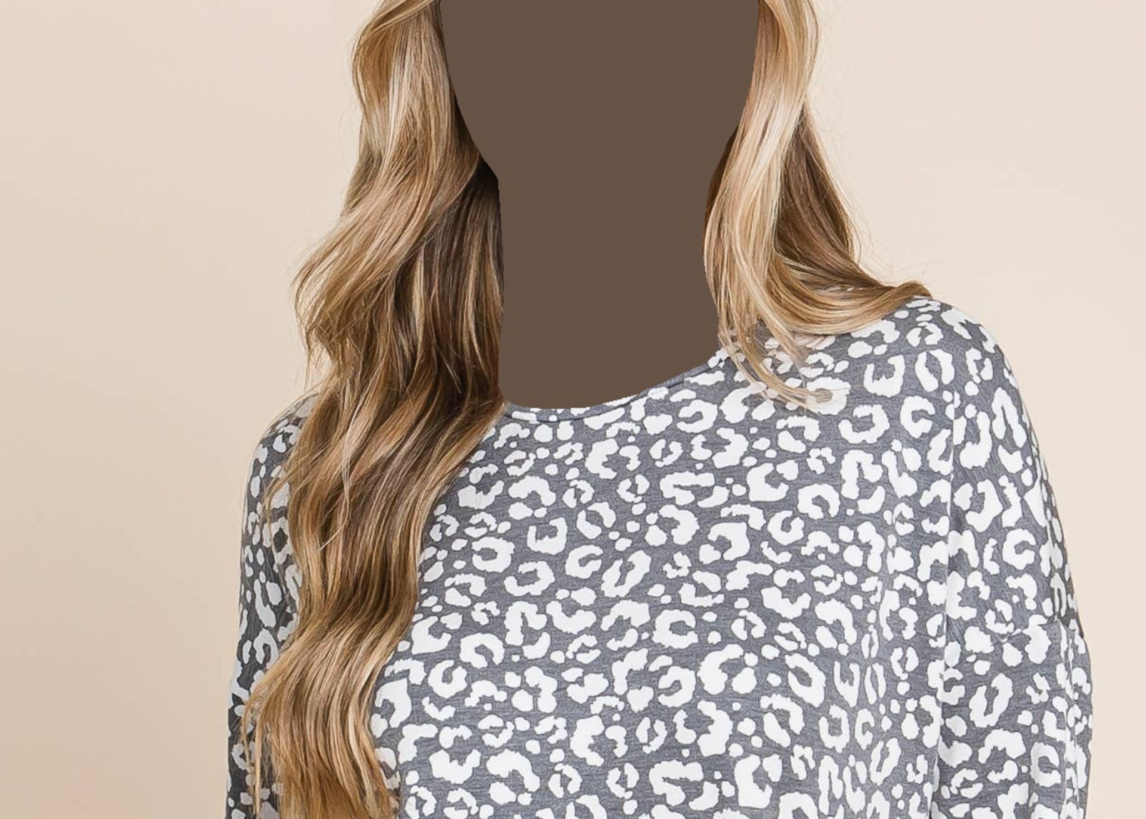 Woman wearing a gray leopard print long-sleeve top against a beige background